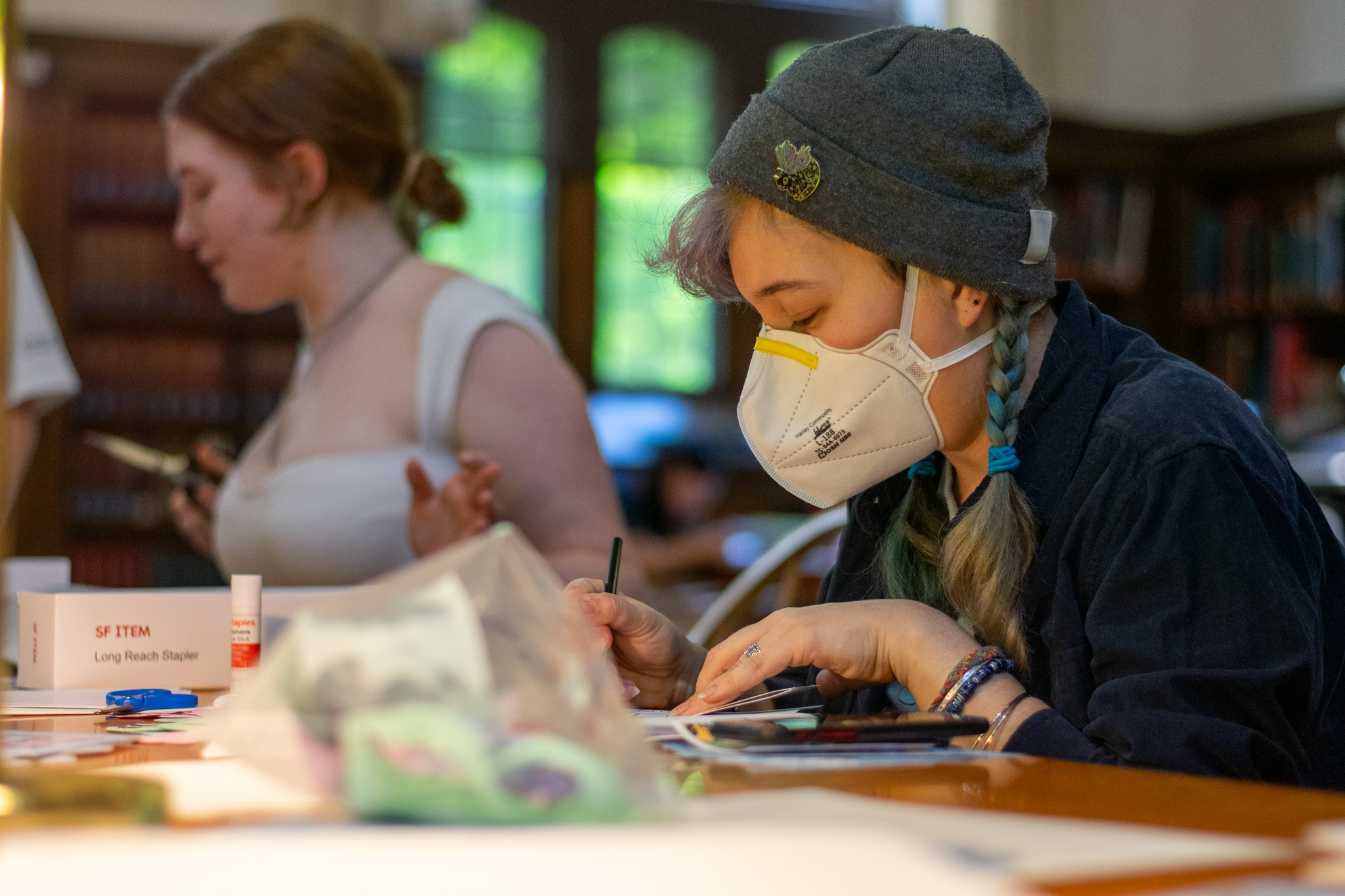 Student making a zine at a table