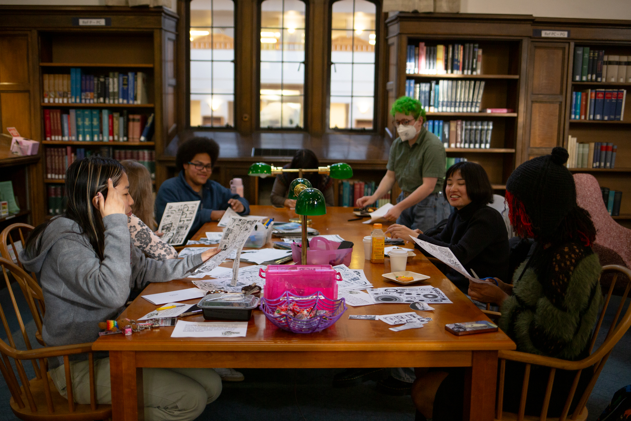 Group of students making zines around a wooden table