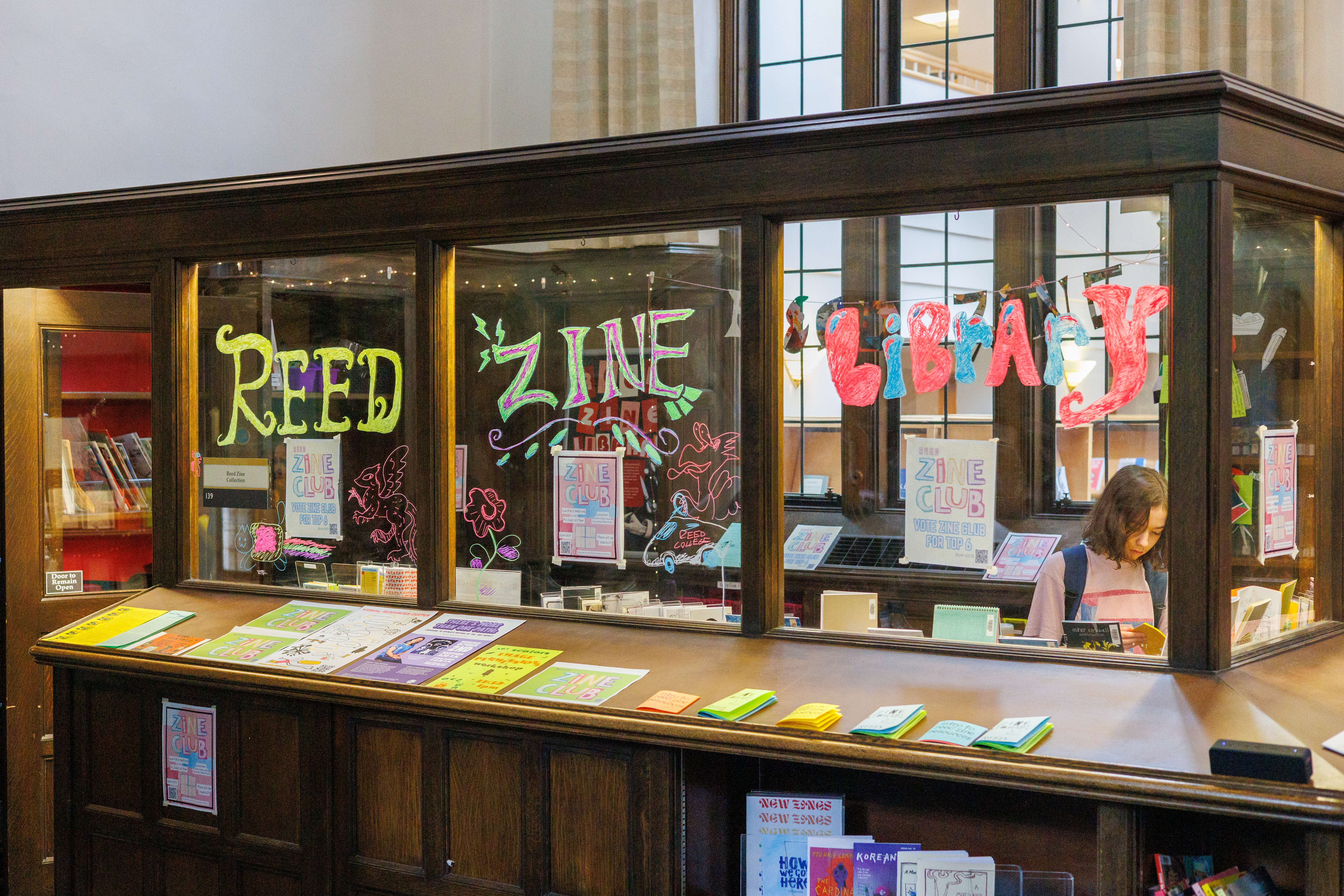 Wooden office with colorful text that says Reed Zine Library